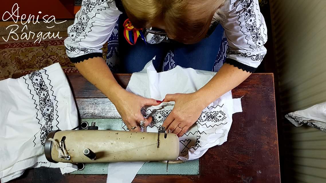 Mirela Groza din Luncoiu de Jos coase la mașină un costum popular cu motive tradiționale